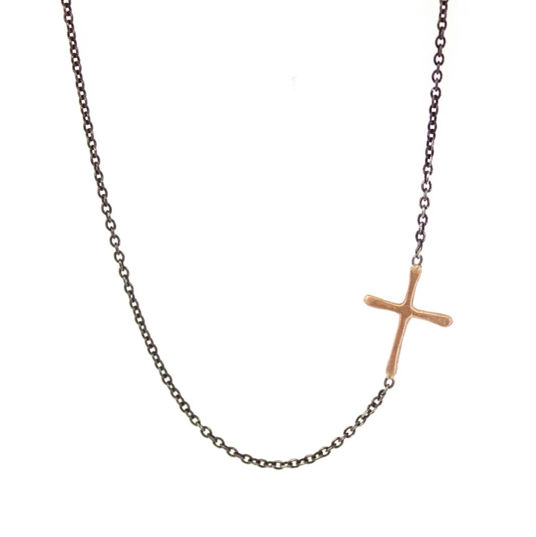 This Sideways Gold Cross is a simple RLD classic. Featuring a gold cross soldered sideways into an oxidized silver chain, this necklace is a subtle reminder of faith and a sweet pop of gold