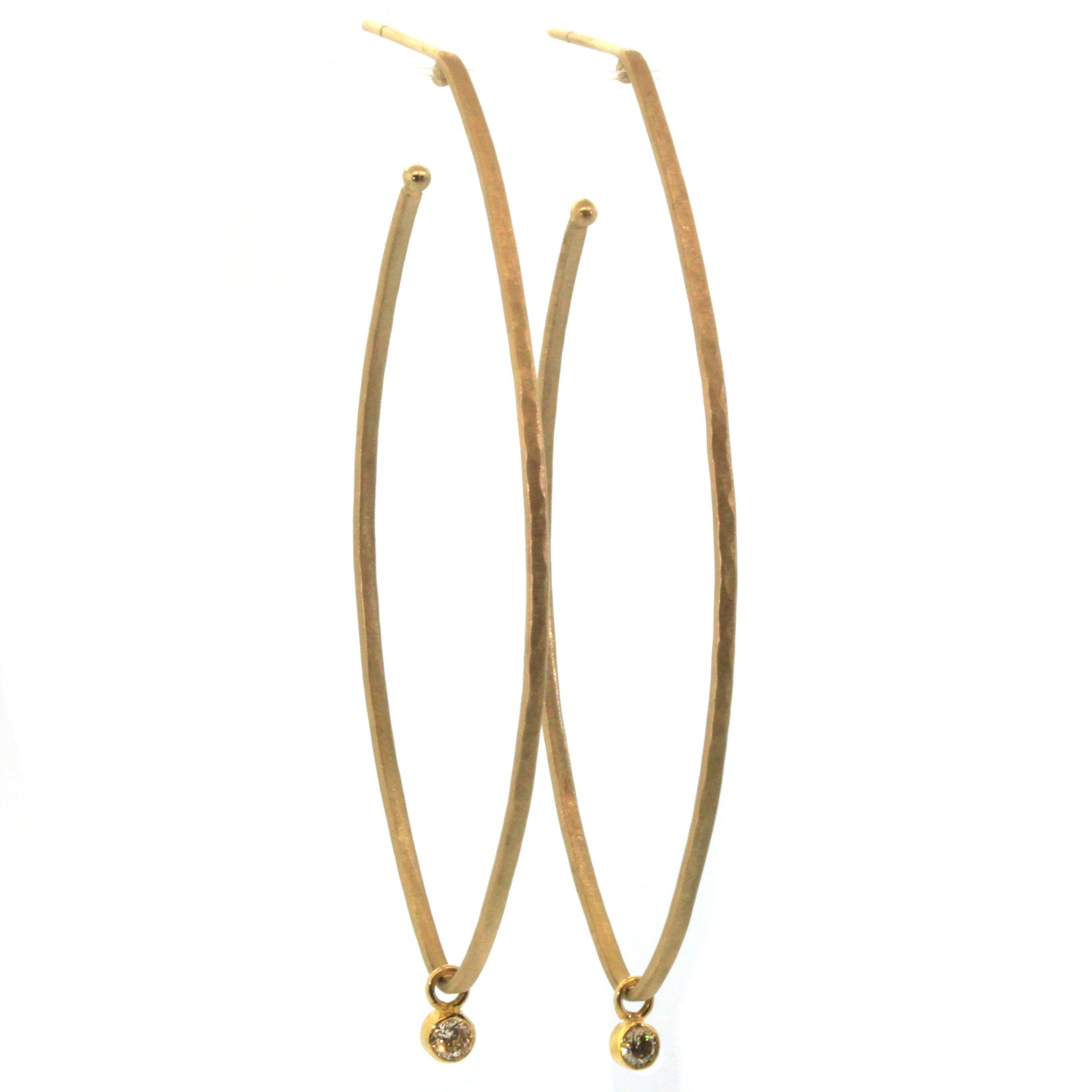 These Elongated Diamond Dangle Hoops from Rebecca Lankford Designs are fit for a queen. Each hoop features a glistening white diamond bezel set and dangling from a textured, yellow gold oval hoop.