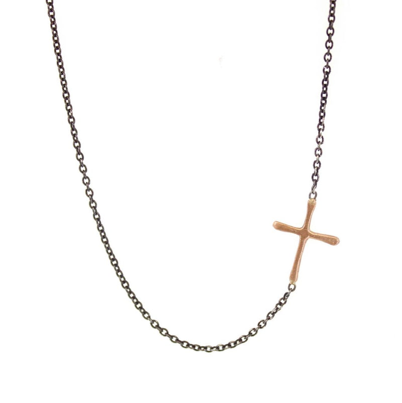 This Sideways Gold Cross is a simple RLD classic. Featuring a gold cross soldered sideways into an oxidized silver chain, this necklace is a subtle reminder of faith and a sweet pop of gold