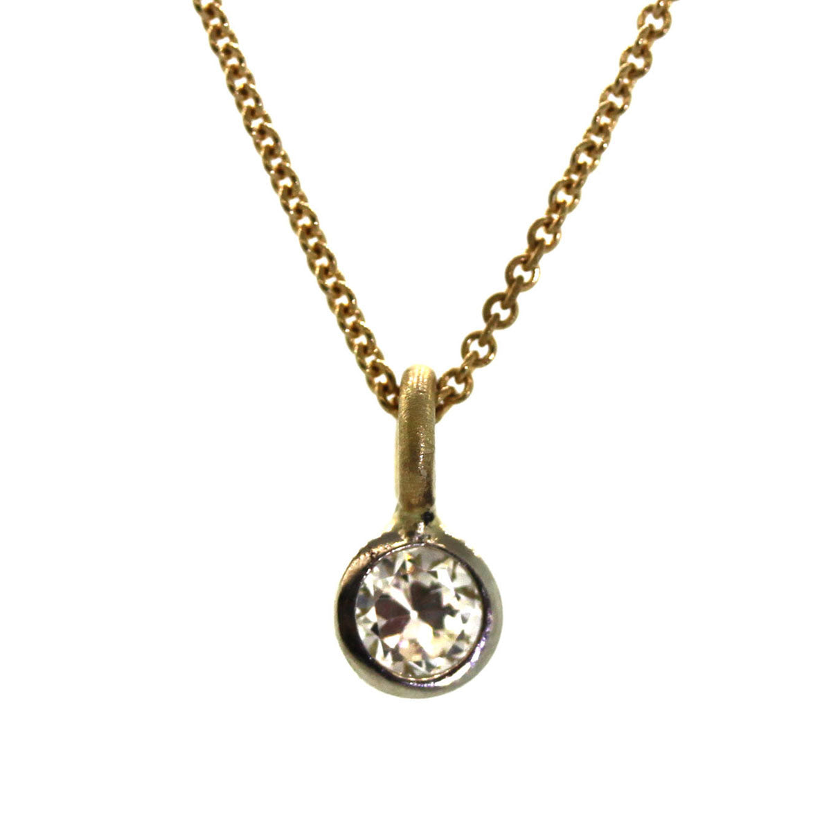 solitaire diamond necklace with a white gold bezel on a yellow gold chain