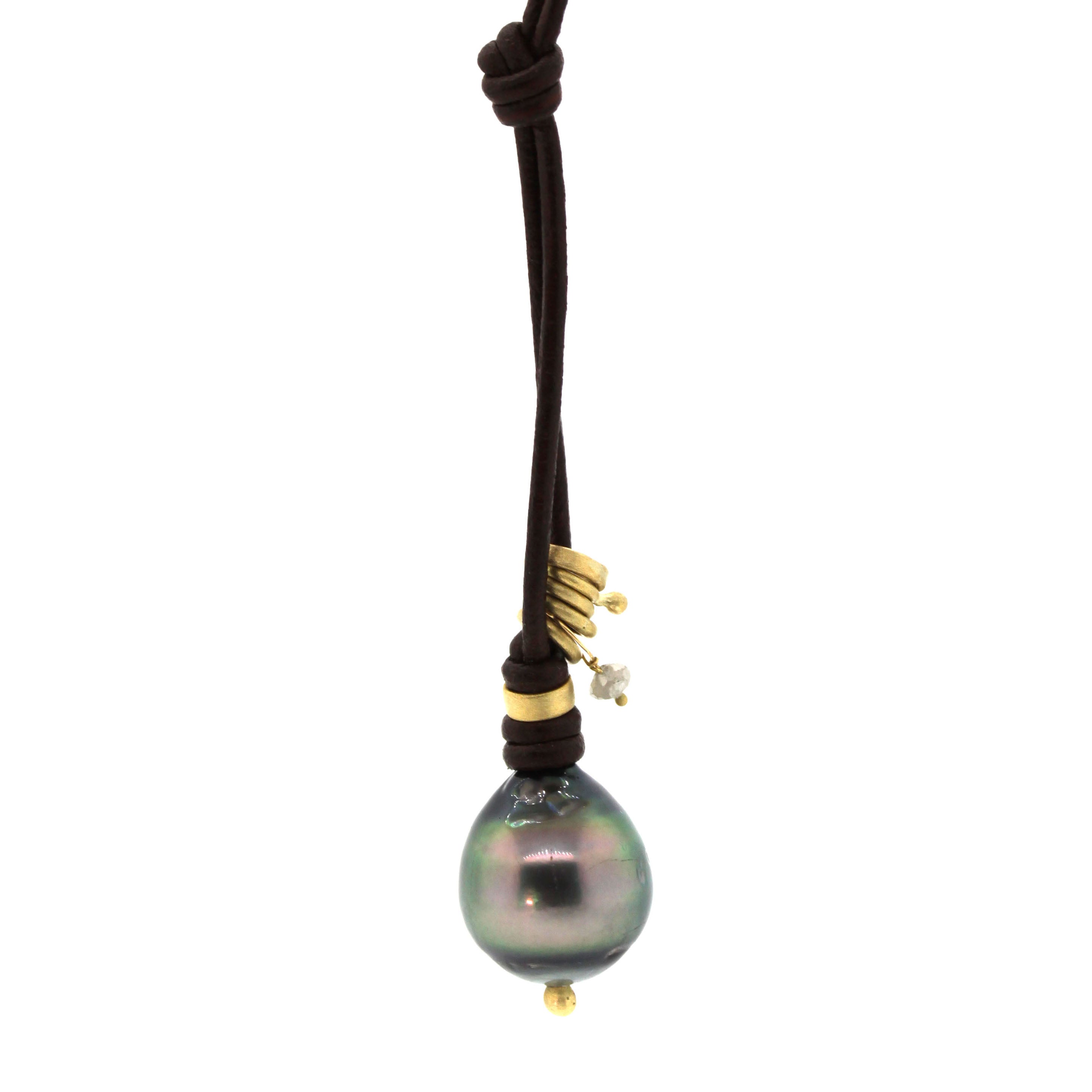 This Charmed Tahitian Pearl Leather Necklace consists of a mix of yellow gold rings and knubs with a diamond dangle all accenting a gorgeous Tahitian Pearl. This piece was handcrafted at Rebecca Lankford Designs in Houston, TX.